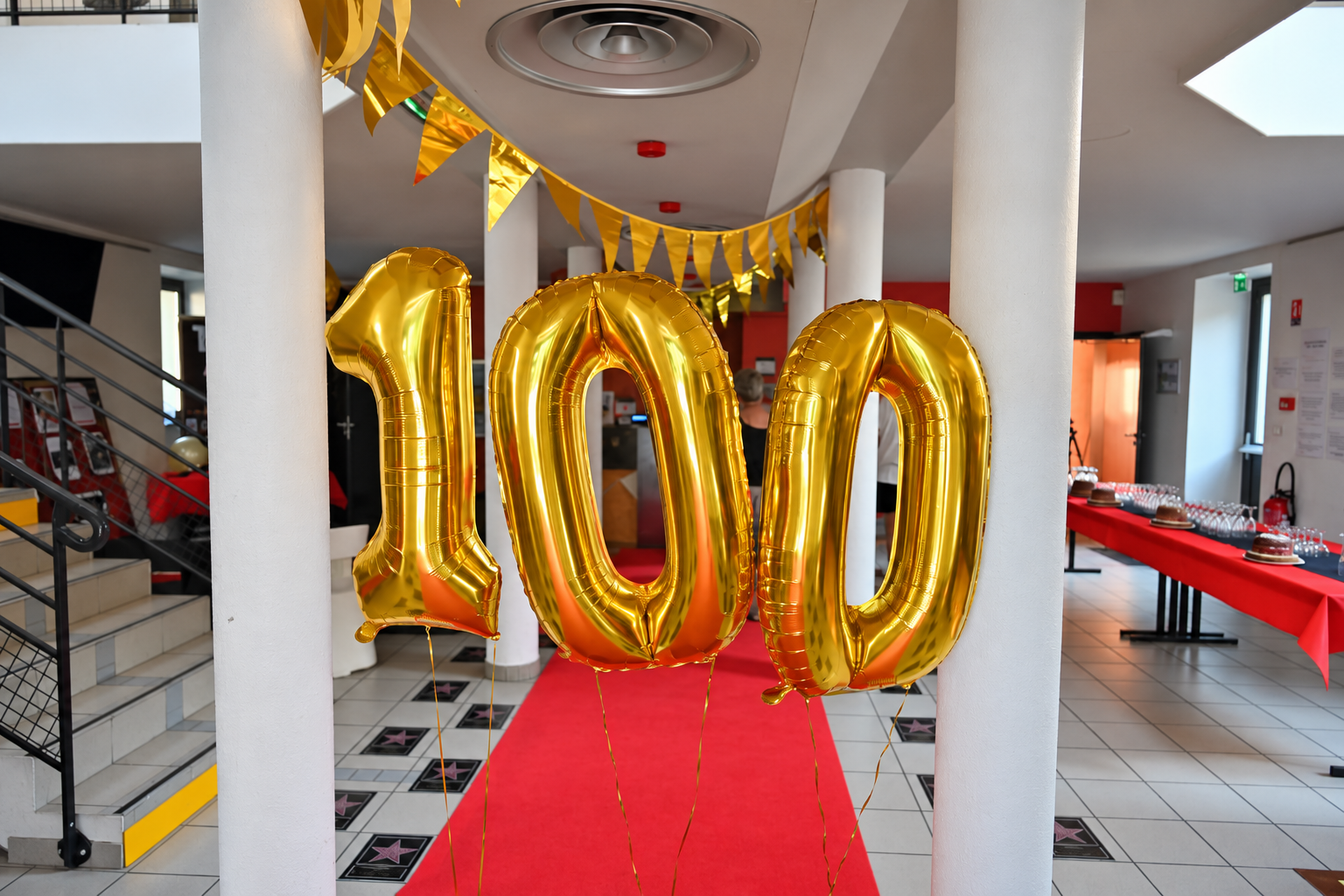 Hall du cinéma décoré pour les 100 ans du Cercle, ballons dorés formant le chiffre 100